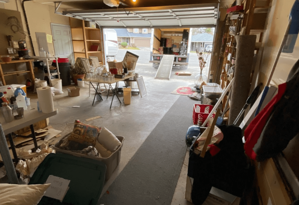 a garage full of estate items ready to be moved into a truck in the driveway